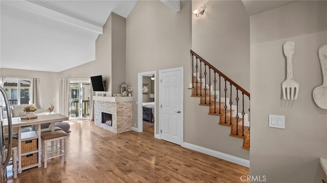 10 Via Garceta, Rancho Santa Margarita, CA 92688 - interior space featuring high vaulted ceiling, a warm lit fireplace, stairway, wood finished floors, and baseboards