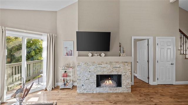 10 Via Garceta, Rancho Santa Margarita, CA 92688 - living area featuring baseboards, a fireplace, wood finished floors, stairs, and high vaulted ceiling