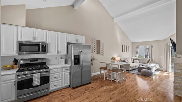 10 Via Garceta, Rancho Santa Margarita, CA 92688 - kitchen featuring light wood-type flooring, open floor plan, white cabinets, appliances with stainless steel finishes, and high vaulted ceiling
