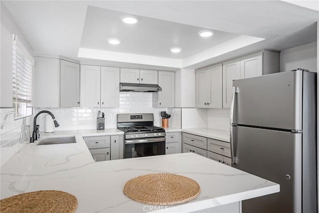 2208 The Strand, Manhattan Beach, CA 90266 - kitchen with a peninsula, a sink, appliances with stainless steel finishes, under cabinet range hood, and a raised ceiling
