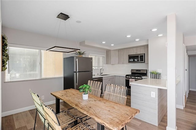 2208 The Strand, Manhattan Beach, CA 90266 - kitchen with modern cabinets, light countertops, backsplash, baseboards, and appliances with stainless steel finishes