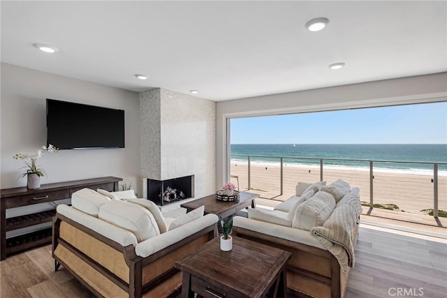 2208 The Strand, Manhattan Beach, CA 90266 - living room featuring wood finished floors, a view of the beach, a water view, a large fireplace, and recessed lighting