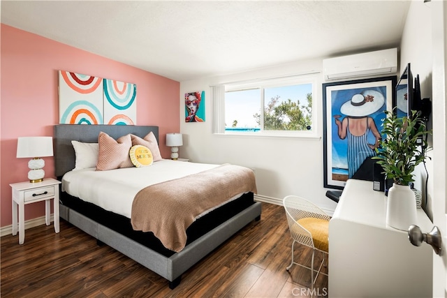 72994 Homestead Dr Unit 29, Palms, CA 92277 - bedroom with a wall mounted AC, dark wood-style flooring, and baseboards