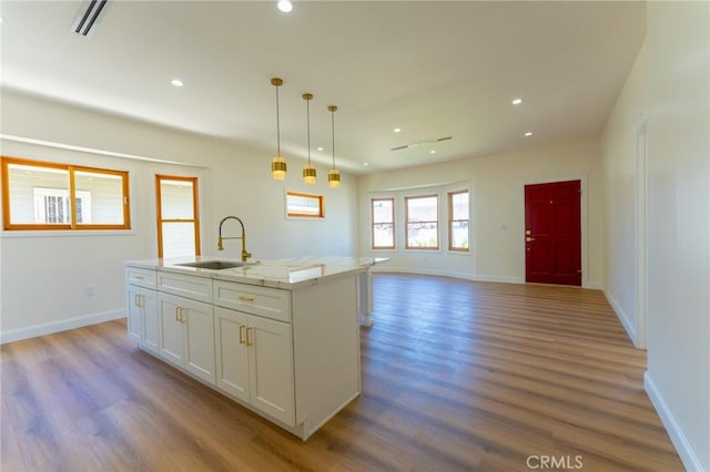 1532 W 22nd St, Los Angeles, CA 90007 - kitchen with a sink, wood finished floors, white cabinetry, recessed lighting, and a center island with sink
