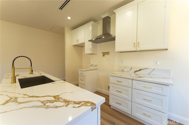 1532 W 22nd St, Los Angeles, CA 90007 - kitchen with wall chimney range hood, a sink, white cabinets, light stone counters, and light wood finished floors