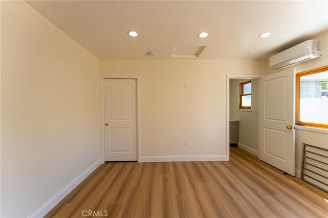 1532 W 22nd St, Los Angeles, CA 90007 - unfurnished room with a wall mounted air conditioner, light wood-style floors, recessed lighting, and baseboards