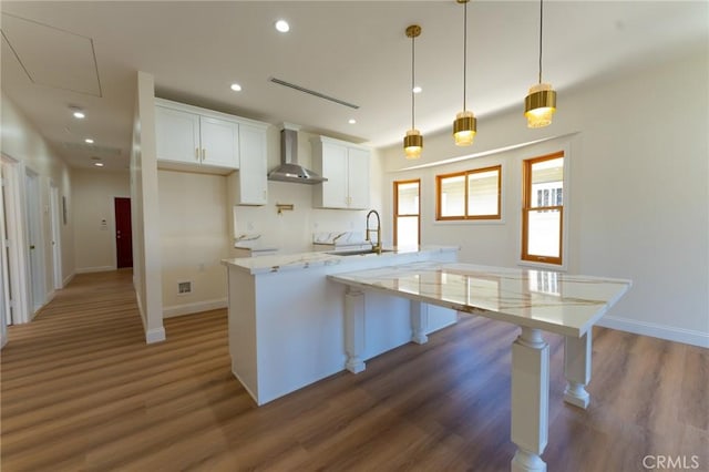 1532 W 22nd St, Los Angeles, CA 90007 - kitchen featuring a sink, wall chimney exhaust hood, wood finished floors, baseboards, and white cabinets