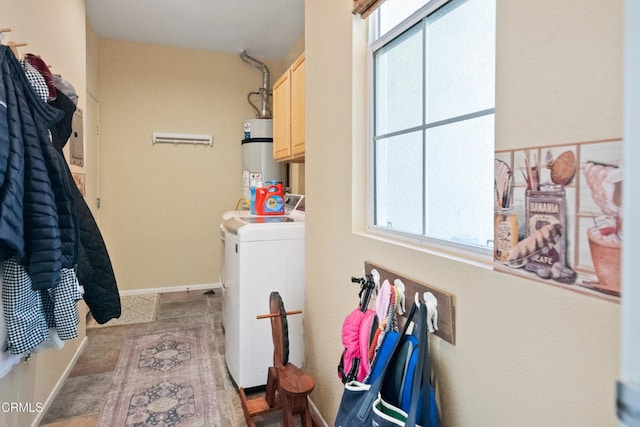 washroom with washer and dryer, strapped water heater, baseboards, and cabinet space