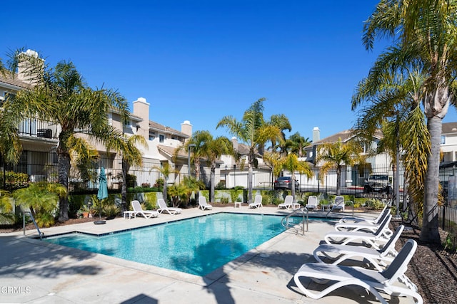 pool with a residential view, fence, and a patio