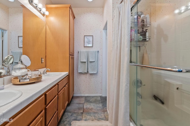full bath featuring baseboards, a sink, enclosed tub / shower combo, double vanity, and wallpapered walls