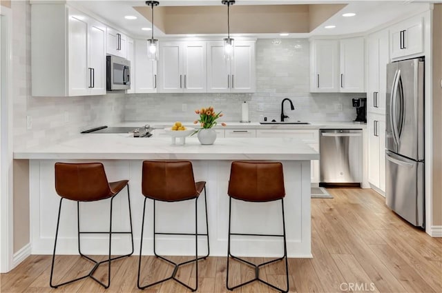 13110 Seaview Ln Unit 245F, Seal Beach, CA 90740 - kitchen with appliances with stainless steel finishes, a peninsula, decorative backsplash, white cabinets, and recessed lighting