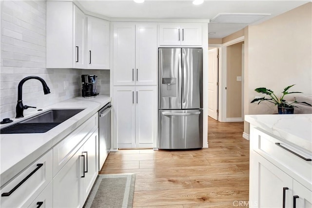 13110 Seaview Ln Unit 245F, Seal Beach, CA 90740 - kitchen with stainless steel appliances, white cabinets, decorative backsplash, light wood-style flooring, and recessed lighting