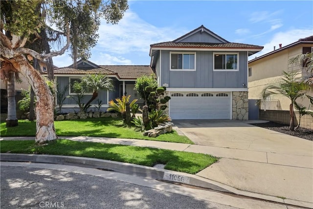 11056 Bigelow Cir, Cerritos, CA 90703 - traditional-style house with driveway, stone siding, board and batten siding, a front yard, and a garage