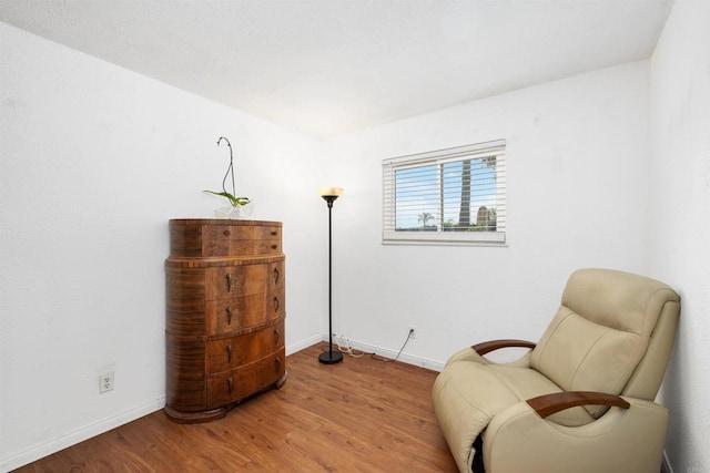 sitting room with baseboards and wood finished floors