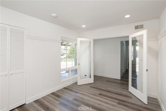 unfurnished bedroom featuring french doors, wood finished floors, recessed lighting, and visible vents