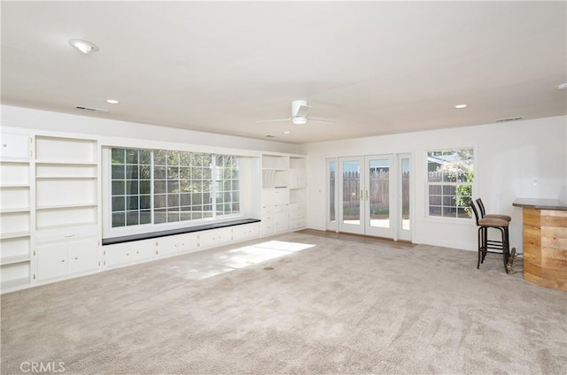 unfurnished living room featuring carpet, baseboards, recessed lighting, a ceiling fan, and french doors
