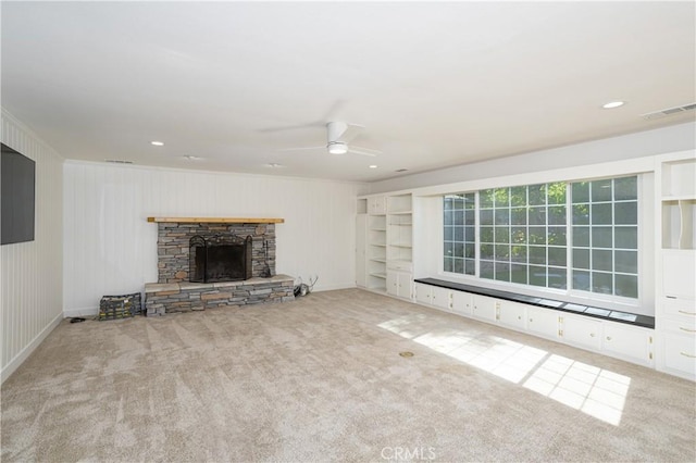 unfurnished living room featuring a fireplace, visible vents, ceiling fan, and carpet flooring