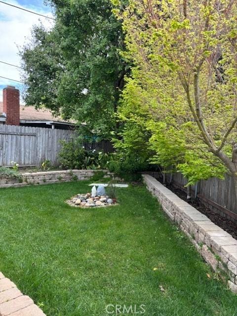 view of yard with a fenced backyard and an outdoor fire pit