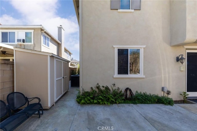 15686 Iron Spring Ln, Fontana, CA 92336 - view of side of property featuring stucco siding, a patio area, and a shed