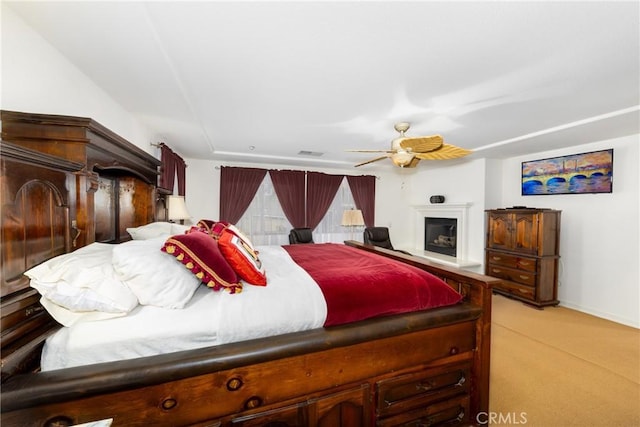 15686 Iron Spring Ln, Fontana, CA 92336 - bedroom with light colored carpet, a glass covered fireplace, and ceiling fan