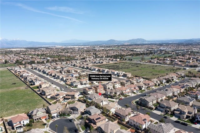 15686 Iron Spring Ln, Fontana, CA 92336 - aerial overview of property's location with a mountain backdrop and nearby suburban area