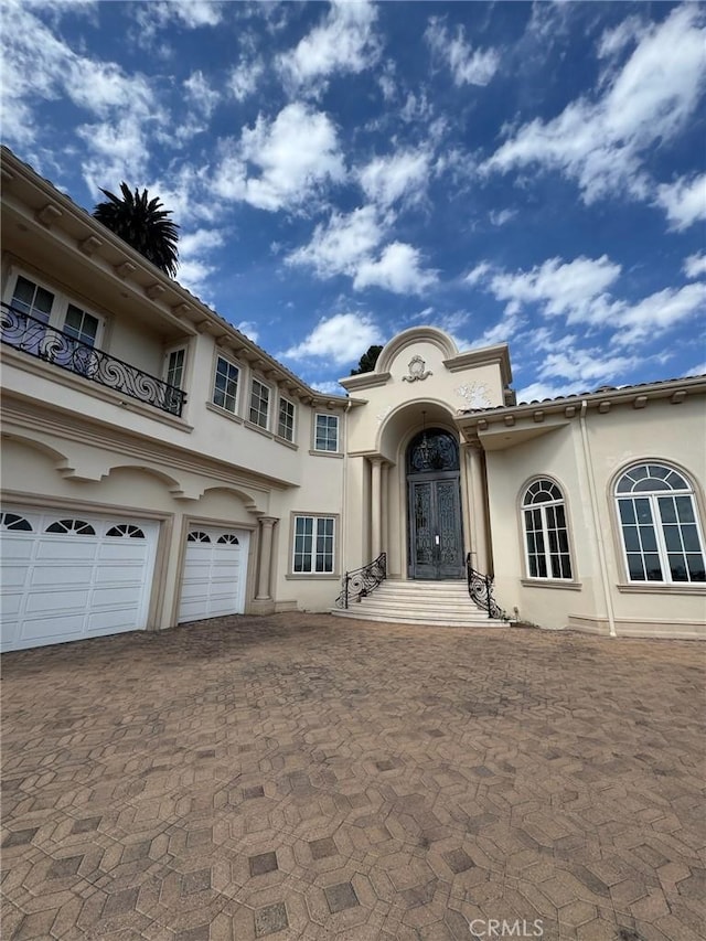 2025 E Live Oak Dr, Los Angeles, CA 90068 - mediterranean / spanish-style home with a balcony, decorative driveway, a garage, and stucco siding