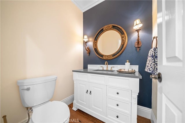 bathroom featuring baseboards, toilet, vanity, and wood finished floors