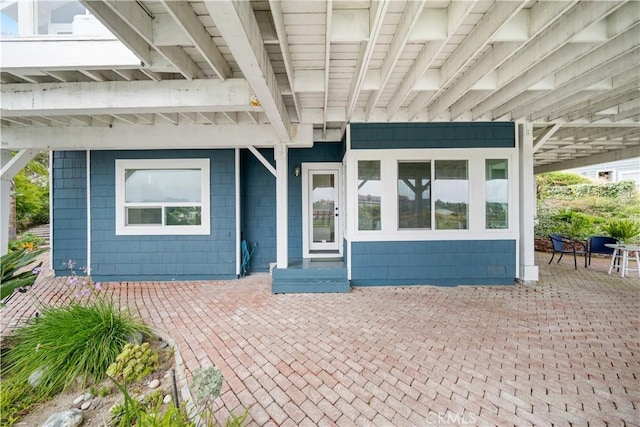 view of exterior entry featuring a patio