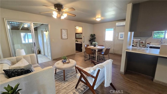 living area featuring a ceiling fan, a wall mounted air conditioner, and light wood-style floors