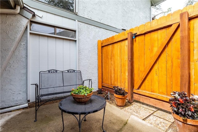 exterior space with fence, a gate, and stucco siding