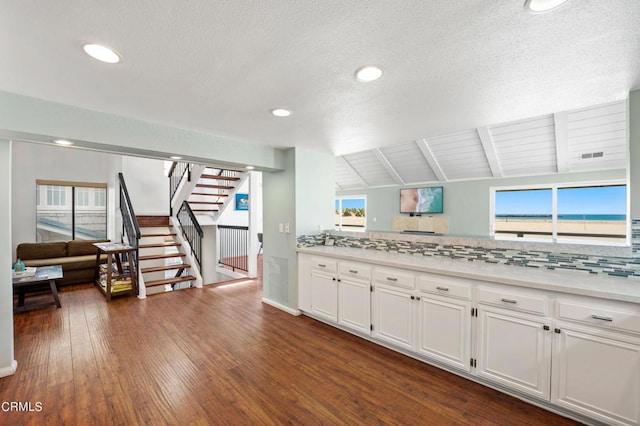 3371 Ocean Dr, Oxnard, CA 93035 - kitchen with light countertops, vaulted ceiling with beams, tasteful backsplash, white cabinetry, and dark wood-style floors
