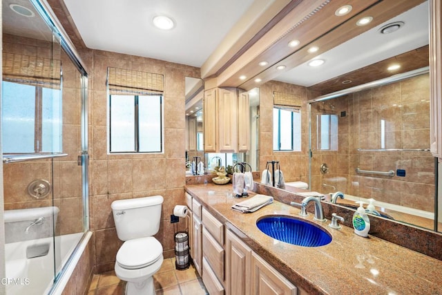 3371 Ocean Dr, Oxnard, CA 93035 - bathroom with tile walls, toilet, vanity, tiled shower / bath, and tile patterned flooring