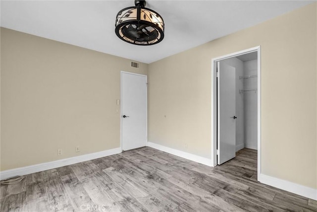 22839 Ridge Route Ln, Lake Forest, CA 92630 - unfurnished bedroom featuring baseboards, visible vents, wood finished floors, a closet, and a walk in closet