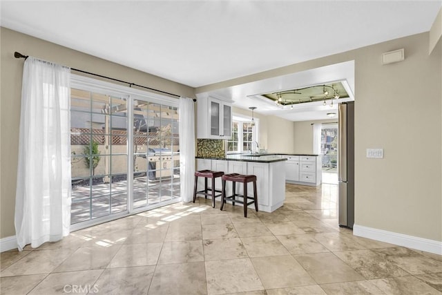 22839 Ridge Route Ln, Lake Forest, CA 92630 - kitchen with a peninsula, baseboards, freestanding refrigerator, and dark countertops