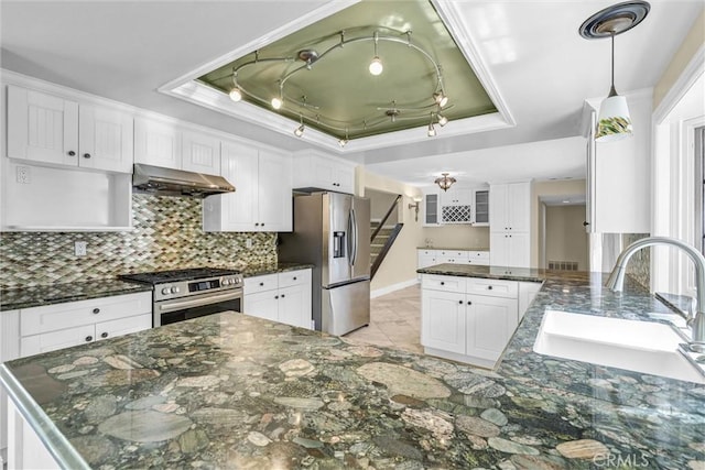 22839 Ridge Route Ln, Lake Forest, CA 92630 - kitchen featuring stainless steel appliances, a tray ceiling, a sink, backsplash, and under cabinet range hood
