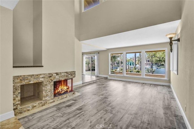 22839 Ridge Route Ln, Lake Forest, CA 92630 - unfurnished living room featuring baseboards, wood finished floors, a towering ceiling, and a multi sided fireplace