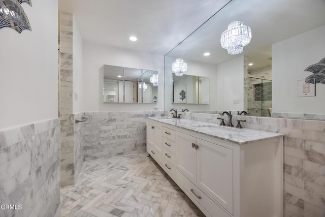 380 S Orange Grove Blvd Unit 6, Pasadena, CA 91105 - full bathroom featuring tile walls, a chandelier, tiled shower, double vanity, and wainscoting