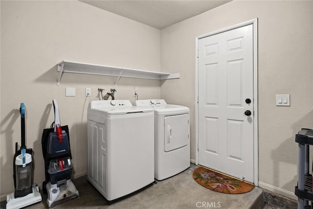 clothes washing area featuring washer and clothes dryer, laundry area, and baseboards
