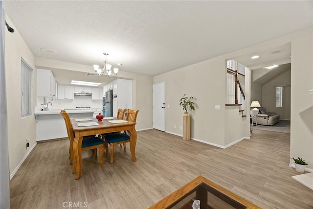 dining area featuring a chandelier, light wood finished floors, and baseboards