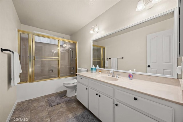 full bathroom with stone finish flooring, toilet, vanity, and bath / shower combo with glass door