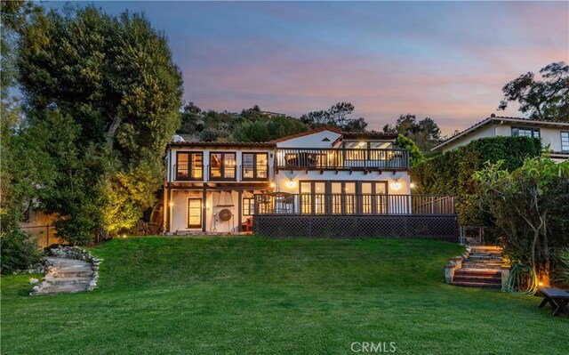 541 Via Del Monte, Palos Verdes Estates, CA 90274 - back of property at dusk with a balcony, a wooden deck, a yard, and stucco siding