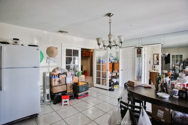 dining room featuring french doors, a chandelier, and light tile patterned floors