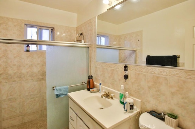 full bathroom with tiled shower, toilet, and vanity