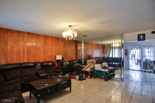 living area featuring a chandelier, wooden walls, and light tile patterned flooring