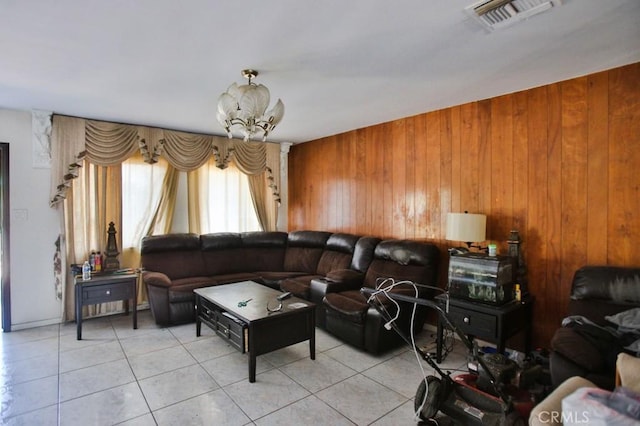 living room with wooden walls, light tile patterned flooring, and a chandelier