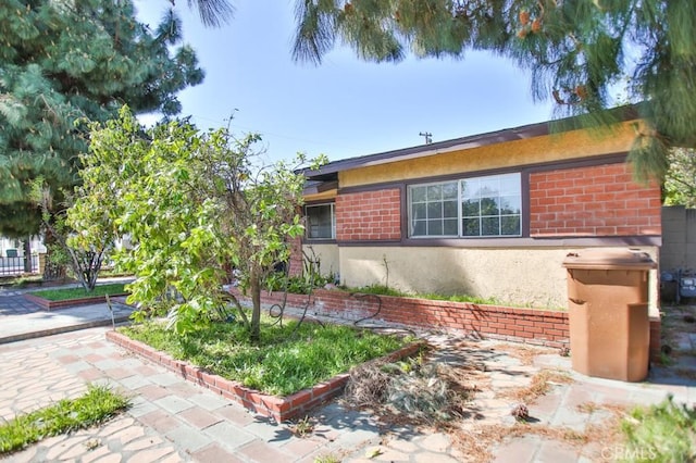 view of property exterior featuring brick siding and stucco siding