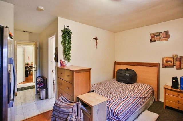bedroom featuring freestanding refrigerator