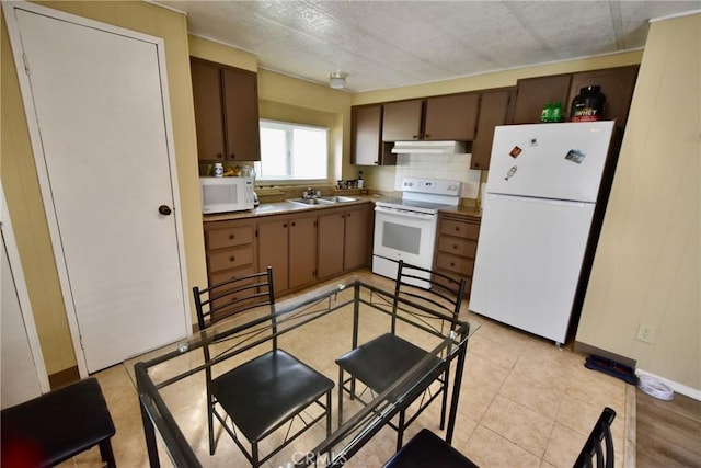 14804 Oregon Rd, Hornbrook, CA 96044 - kitchen featuring tasteful backsplash, white appliances, under cabinet range hood, a sink, and light tile patterned flooring