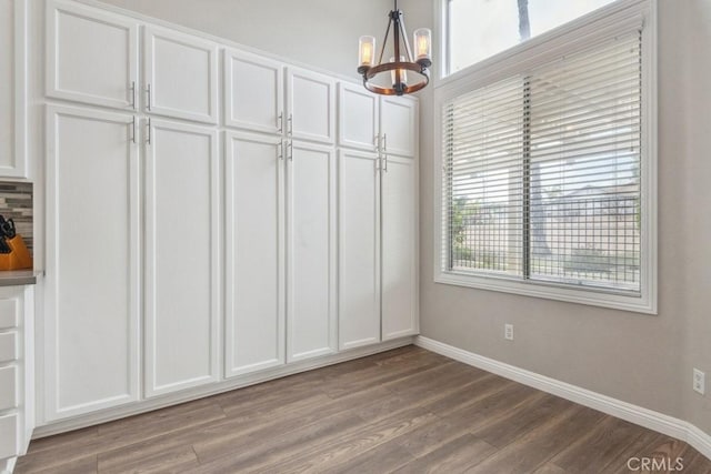 40049 Corte Fortuna, Murrieta, CA 92562 - unfurnished dining area featuring a chandelier, baseboards, and wood finished floors