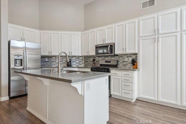 40049 Corte Fortuna, Murrieta, CA 92562 - kitchen with appliances with stainless steel finishes, a sink, tasteful backsplash, wood finished floors, and white cabinetry